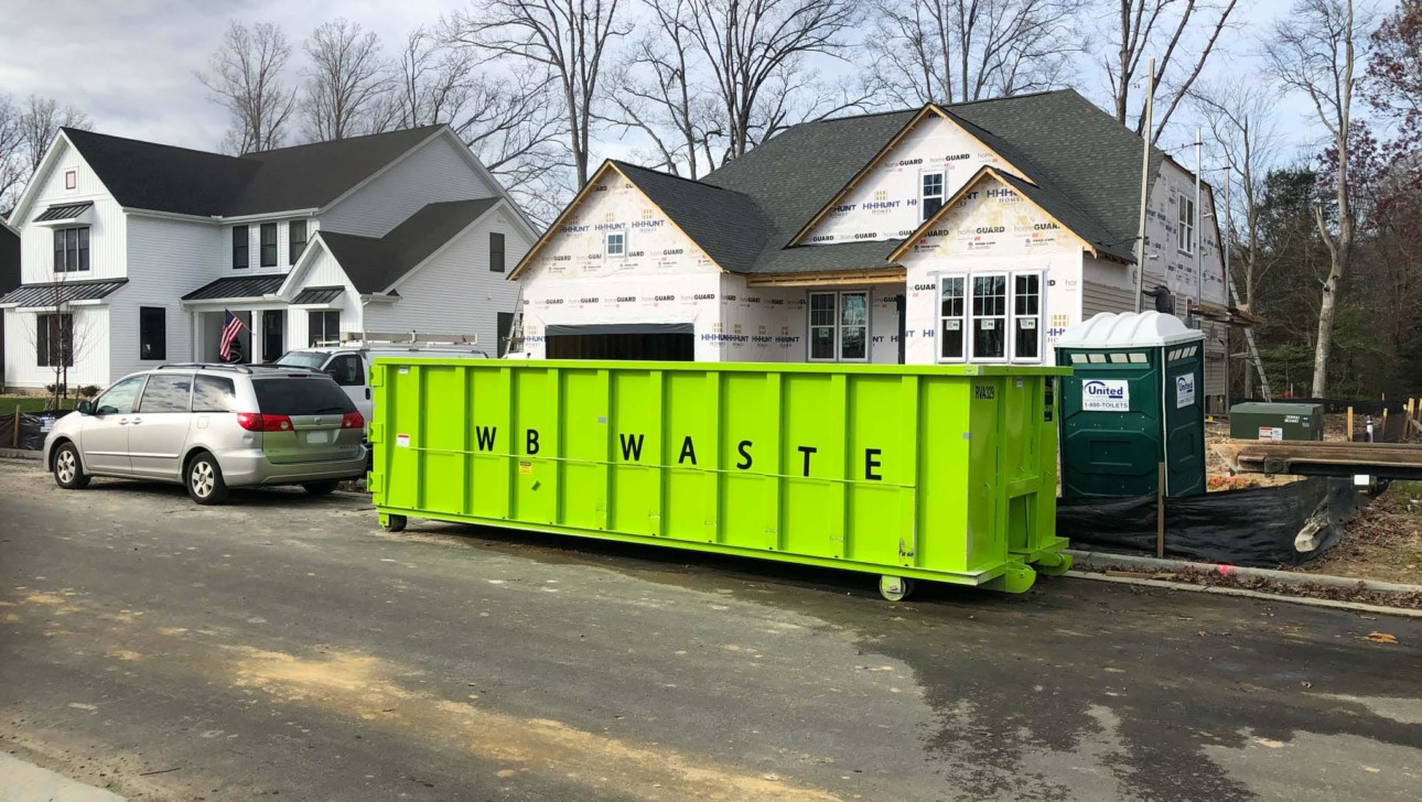 residential roll of dumpster in front of house under construction.